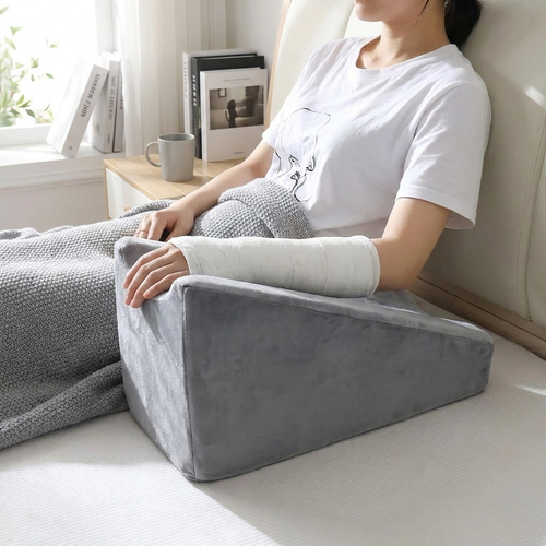 Woman resting arm in gray wedge arm elevation pillow groove